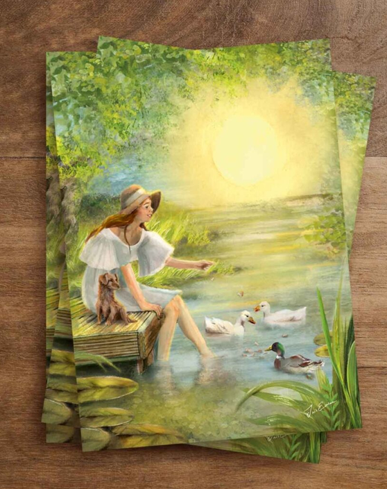 Illustratiekaart Simple Joys van Iris Esther met een vrouw op een steiger die eenden voert aan het water met ondergaande zon