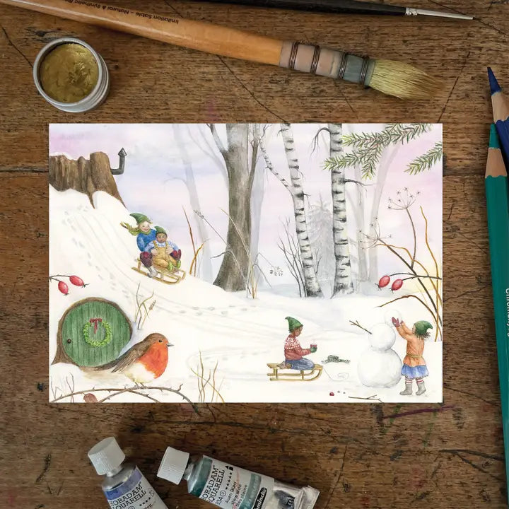 Ansichtkaart Snow day van Mhairi Hellbrandt Illustraties met kabouters die sleeën in een besneewd bos