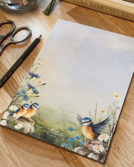 Little Wings A5 notitieblok van Iris Esther met illustratie van een pimpelmees moeder en jonge vogels tussen bloemen.